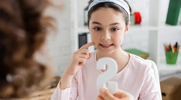 A young girl practicing pronunciation